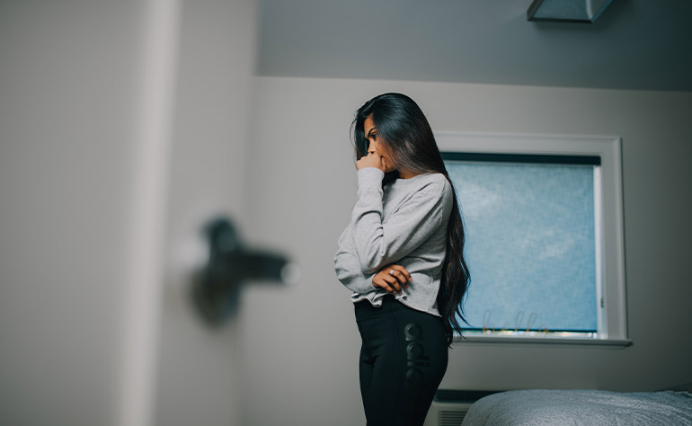 Woman individual in her quarters grappling with depression effects.