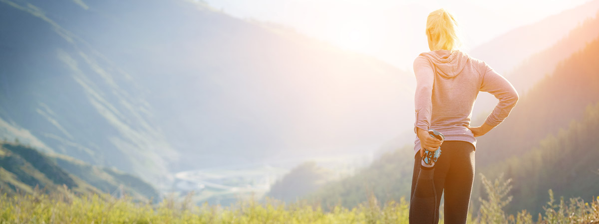 runner stretching in front of a beautiful mountain scene